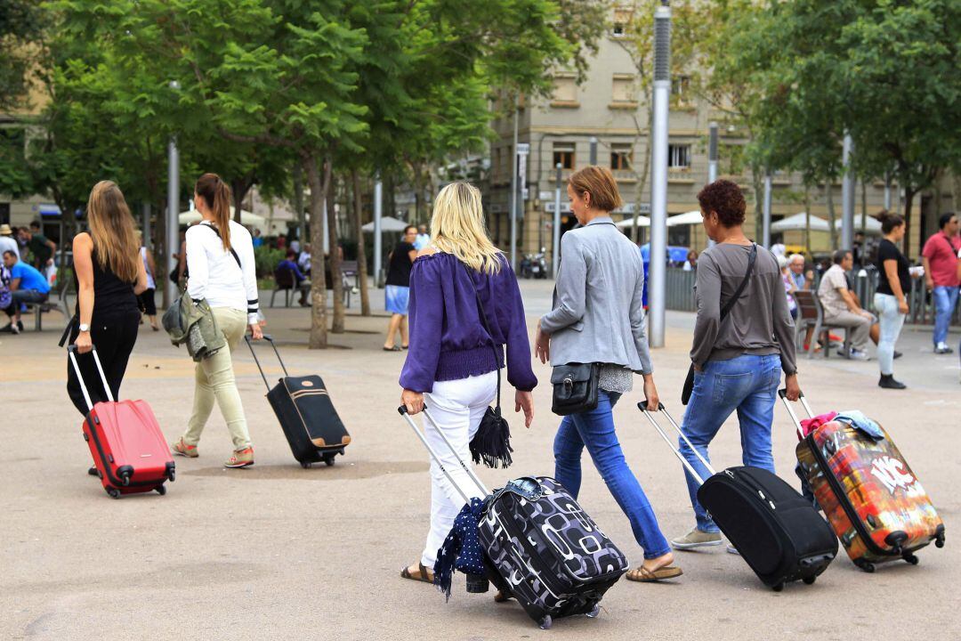 Varios turistas con maletas. 