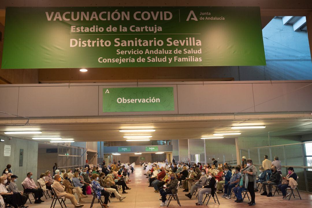 Varias personas esperan en el área de observación después de que les hayan administrada  la vacuna contra el Covid-19, en el Estadio de la Cartuja, en Sevilla, (España)