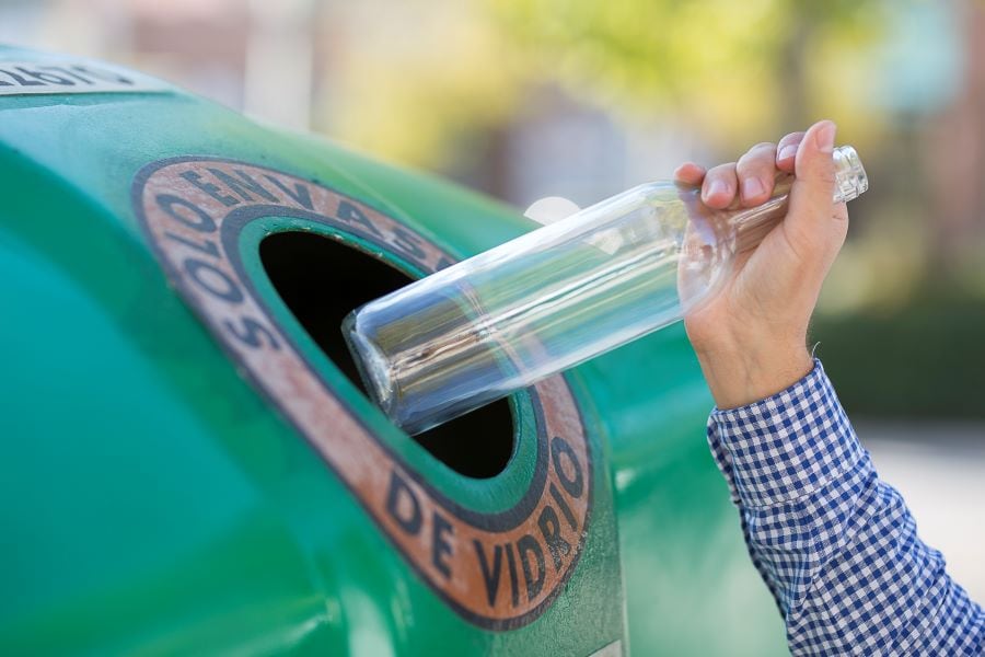 Una persona recicla una botella de vidrio, en una imagen de archivo