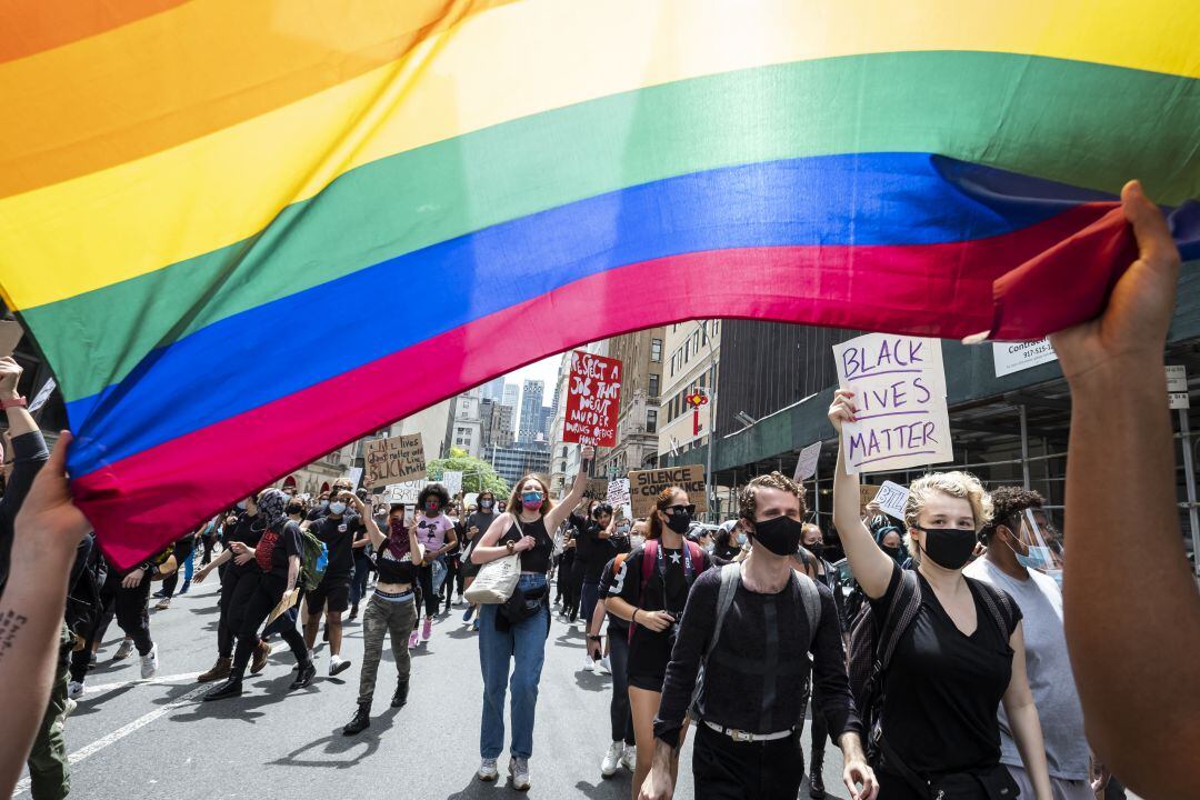 Manifestantes norteamericanos portan la bandera LGTB durante las protestas antirracistas en el país