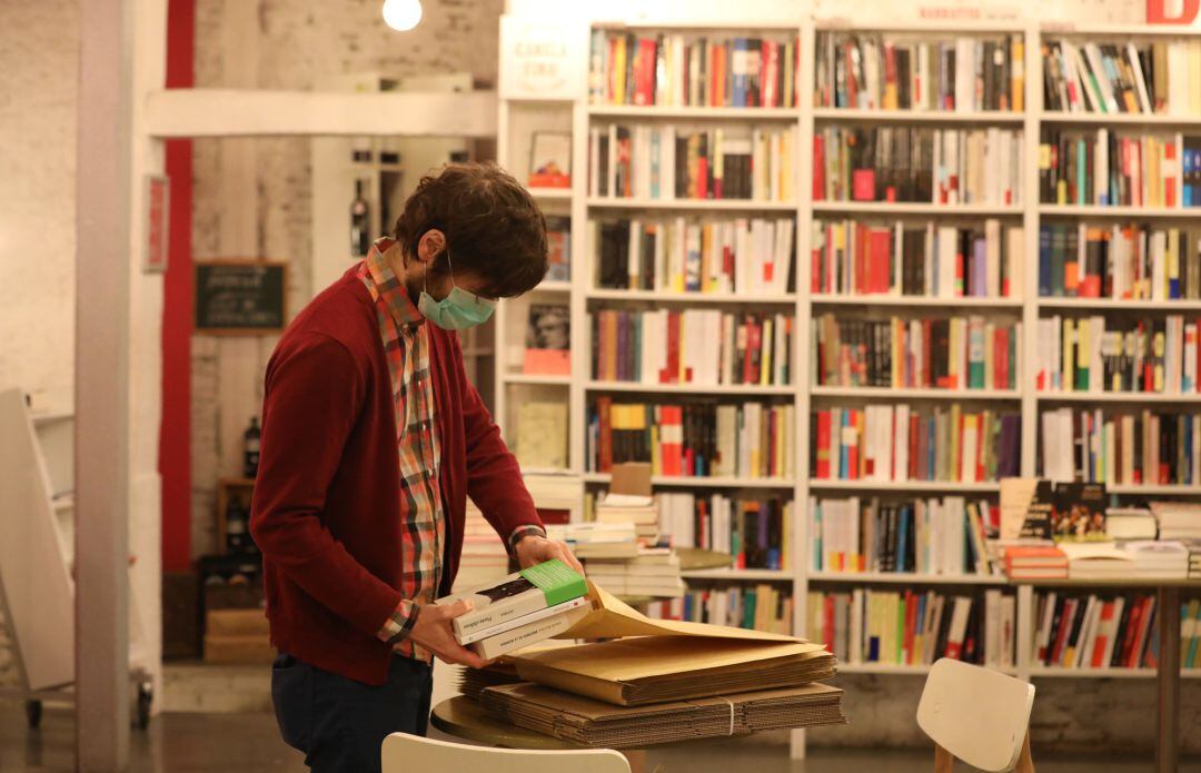 Gonzalo, dueño de la librería &#039;Tipos Infames&#039;, ubicada en la madrileña calle de San Joaquín mientras prepara pedidos online.