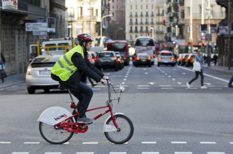 Usuario del servicio de alquiler de bicicletas Bicing circulando en vía urbana.