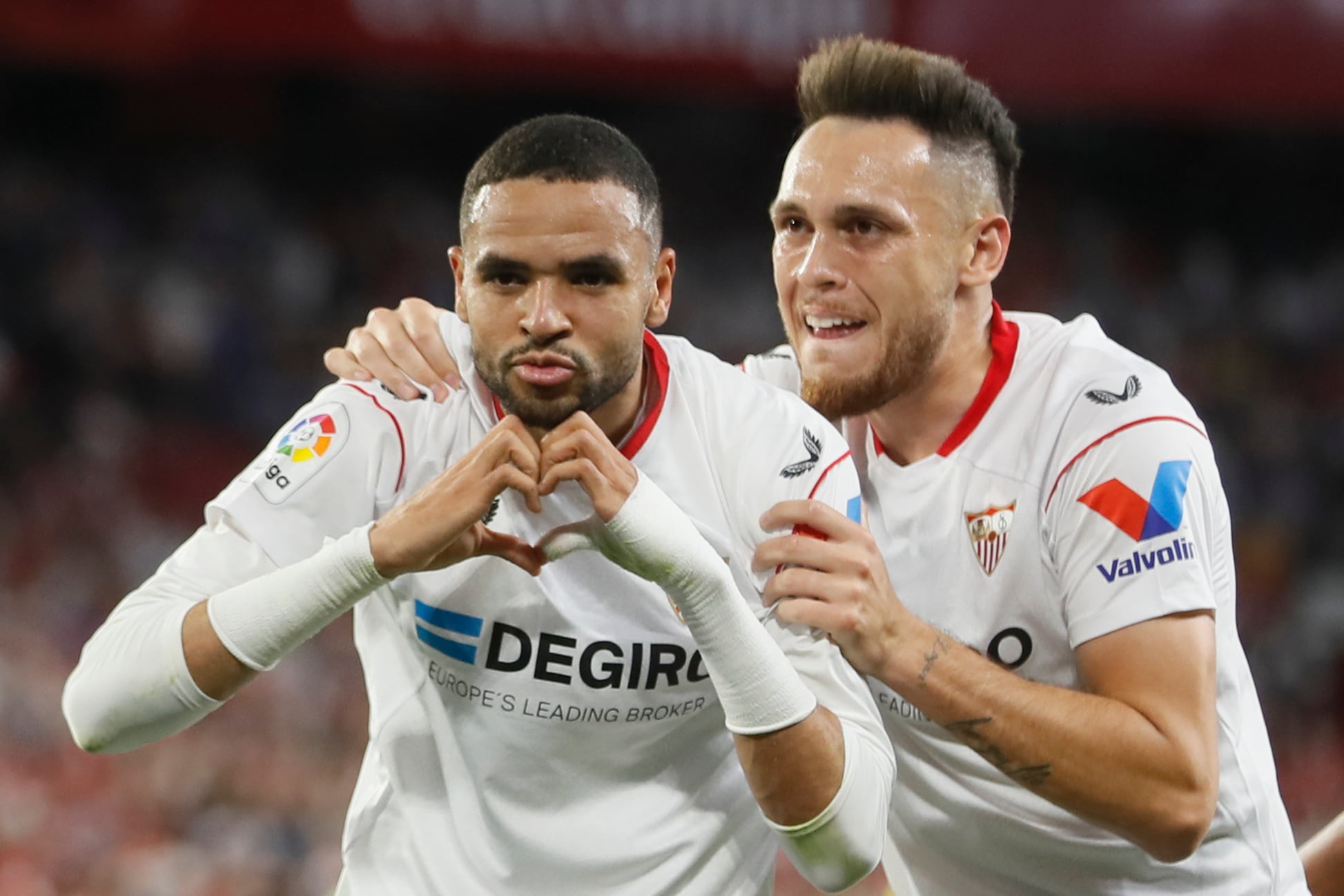 Sevilla, 23/04/2023.- El delantero marroquí del Sevilla, Youssef En-Nesyri (i), celebra con su compañero, el argentino Lucas Ocampos, el segundo gol del equipo andaluz durante el encuentro correspondiente a la jornada 30 de primera división que han disputado hoy domingo frente al Villarreal en el estadio Sánchez Pizjuán, en Sevilla. EFE/José Manuel Vidal.
