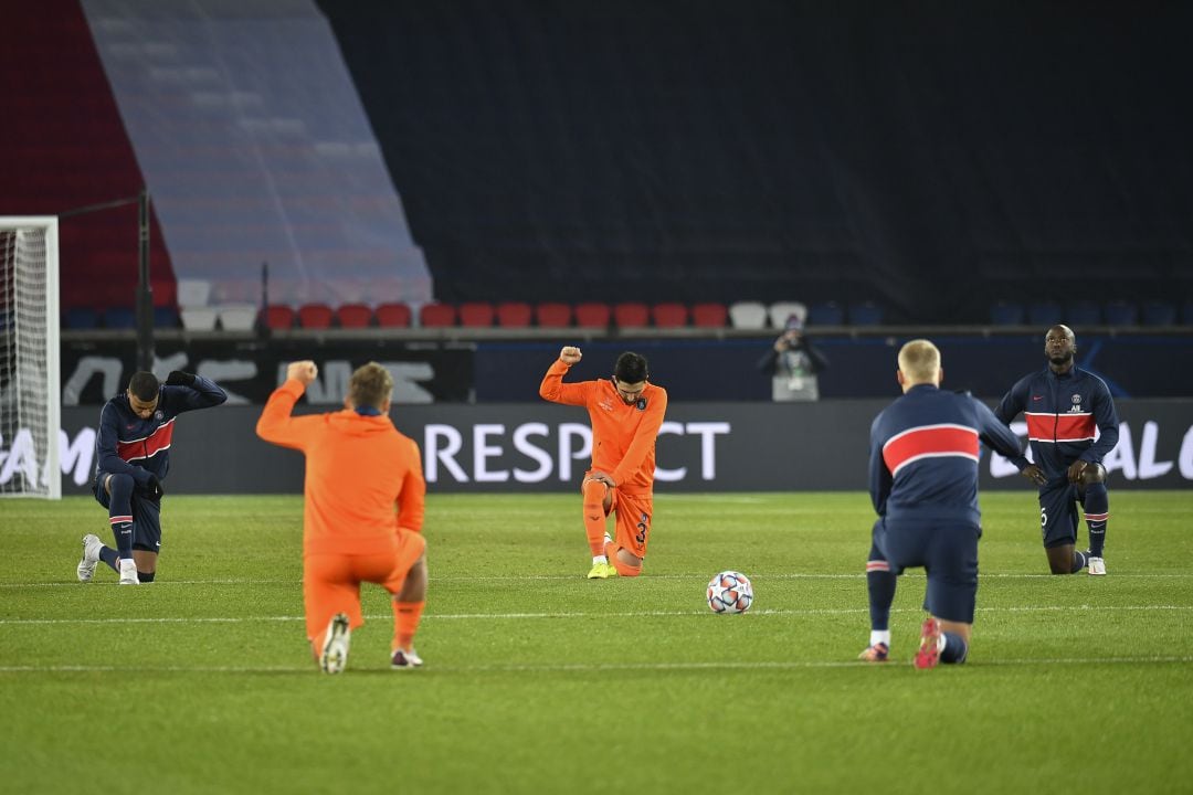 Los jugadores del PSG y el Basaksehir, arrodillados antes de la reanudación del partido. 