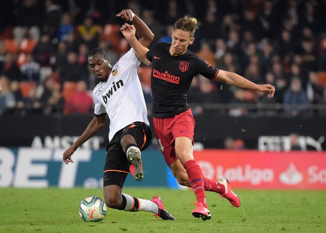 Kondobia pugna por un balón con Llorente, en un Valencia - Atlético de Madrid