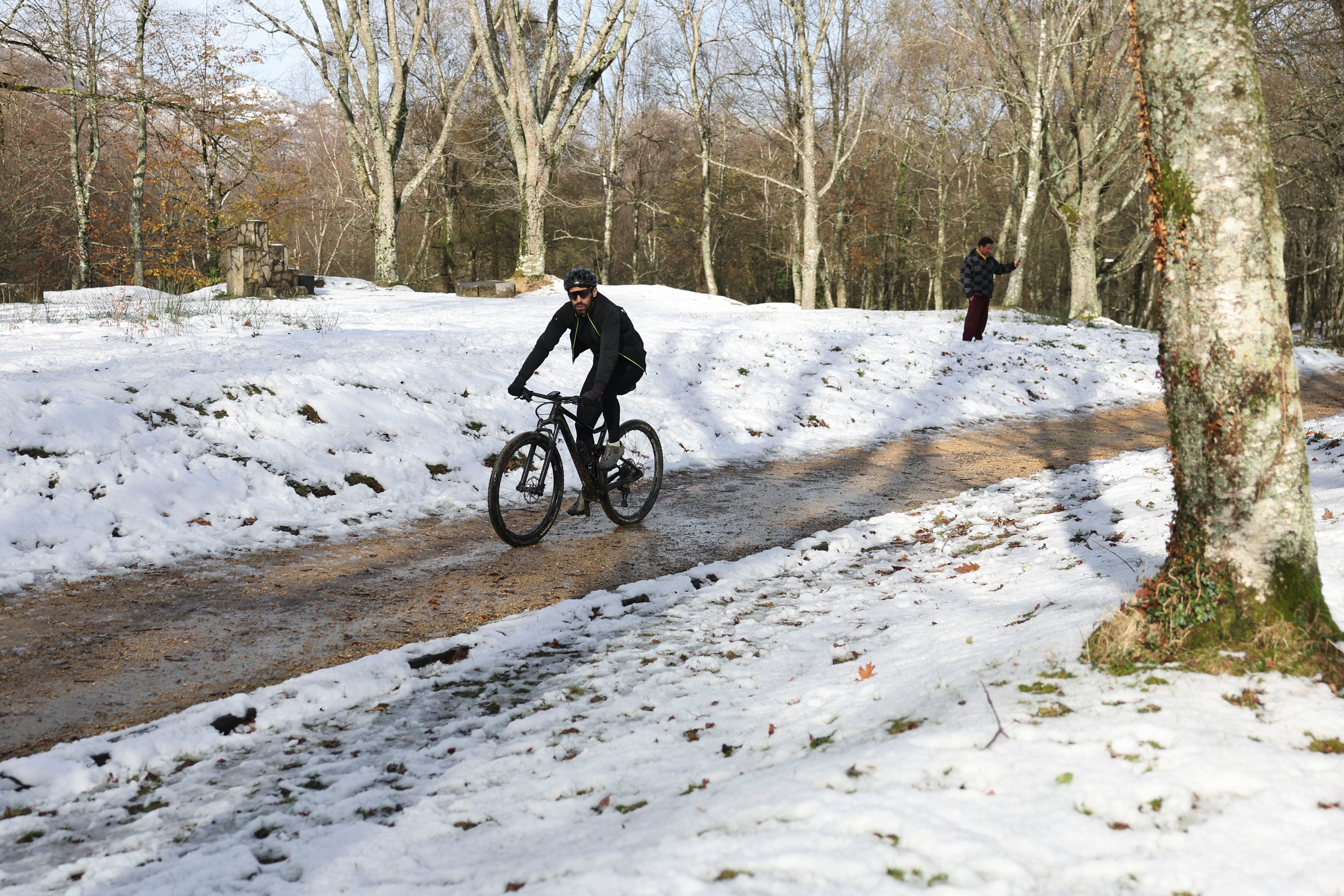 Un cicloturista disfruta de la nieve en el alto de Urkiola en Bizkaia.