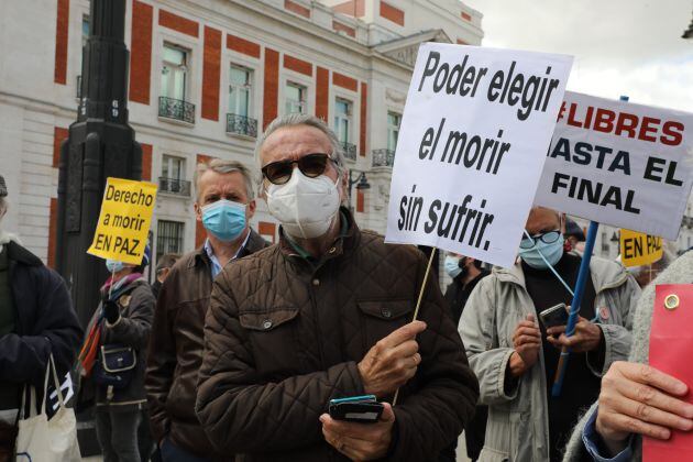 Un hombre con un cartel en el que se lee: `Poder elegir el morir sin sufrir´ durante una concentración de Derecho a Morir Dignamente en la Puerta del Sol, en Madrid (España), a 18 de marzo de 2021. Derecho a Morir Dignamente se manifiesta para dar apoyo a