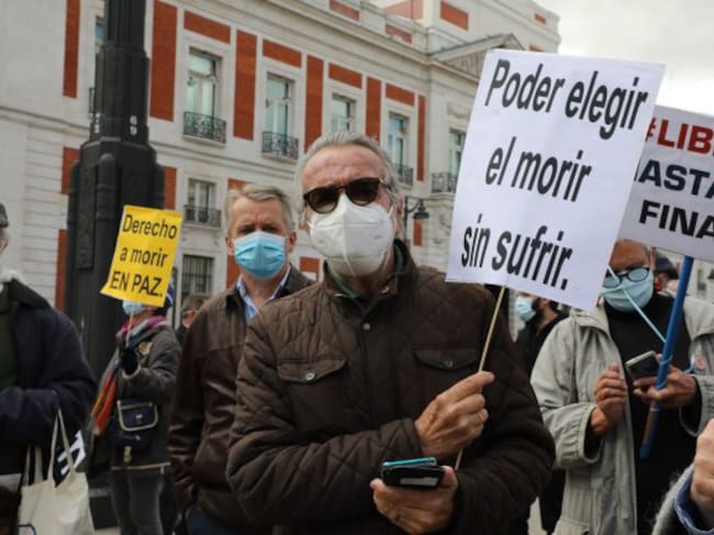 Un hombre con un cartel en el que se lee: `Poder elegir el morir sin sufrir´ durante una concentración de Derecho a Morir Dignamente en la Puerta del Sol, en Madrid (España), a 18 de marzo de 2021. Derecho a Morir Dignamente se manifiesta para dar apoyo a