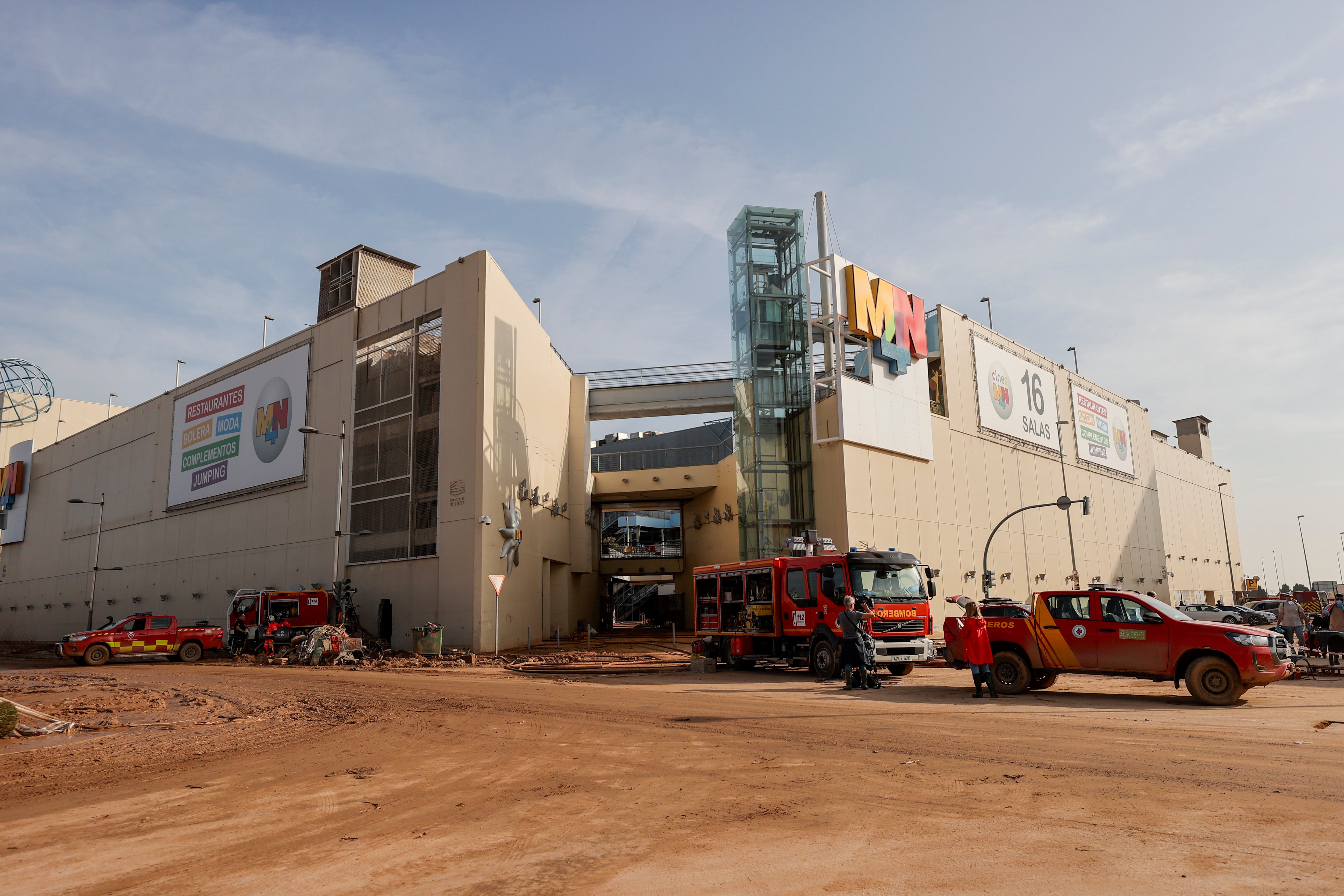 Dotaciones de bomberos utilizan mangueras para sacar el agua del interior del aparcamiento subterráneo del centro comercial MN4, en la localidad valenciana de Alfafar, este martes.