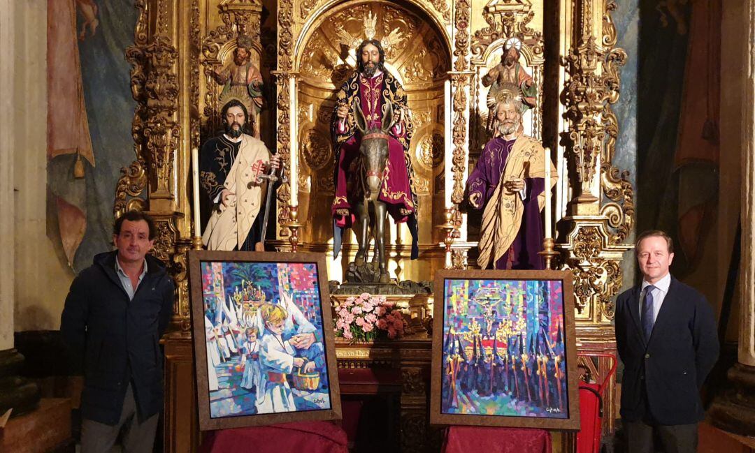 El pintor José Cerezal -a la izquierda- y el hermano mayor del Amor, Juan Cruzado, junto a las obras que ilustrarán las pepeletas de sitio solidarias