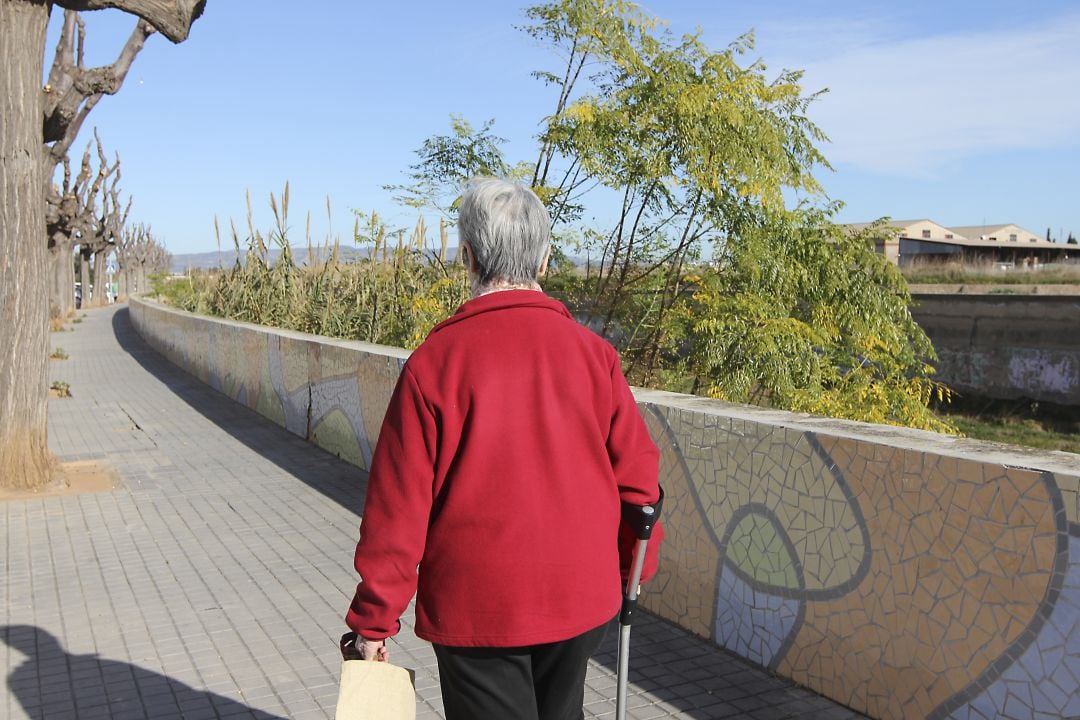 Imagen de una mujer, mayor, caminando por la ciudad de Castelló