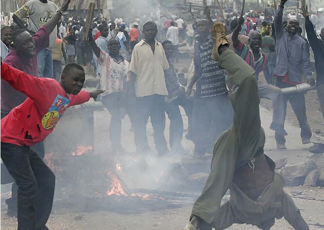 Varios jóvenes gritan ante una hoguera en Nairobi, donde continúan los enfrentamientos entre la población