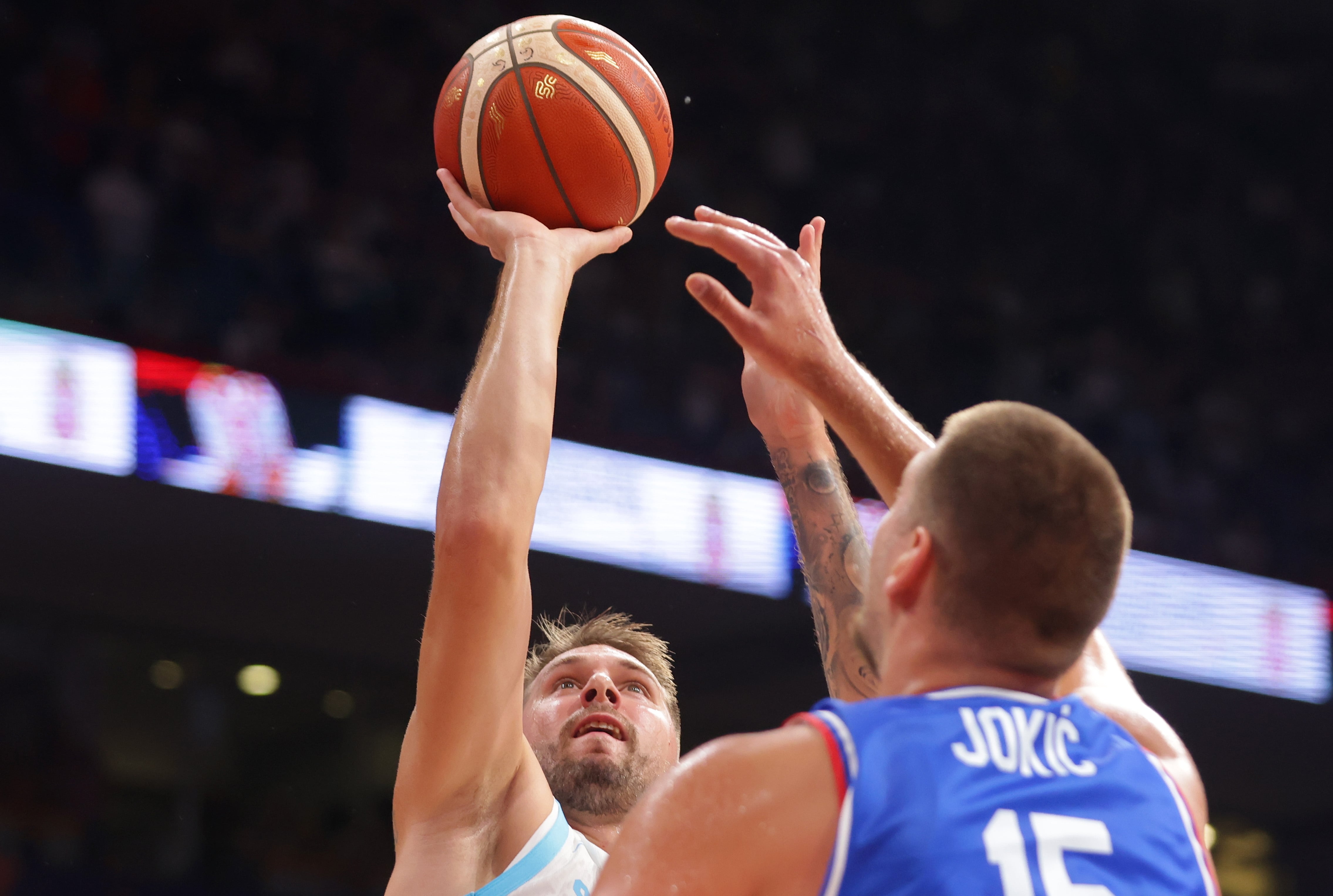Luka Doncic y Nikola Jokic pelean por el rebote en un partido entre Eslovenia y Serbia