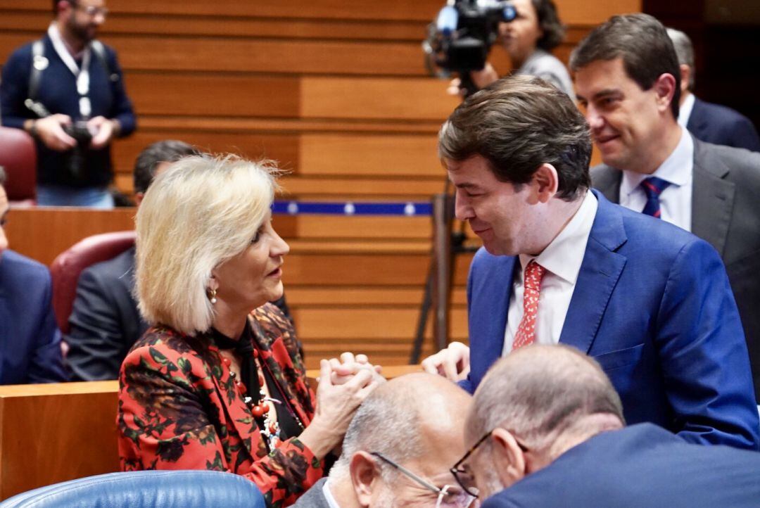 El presidente de la Junta, Alfonso Fernández Mañueco, conversa con la consejera de Sanidad, Verónica Casado, en el Pleno de las Cortes