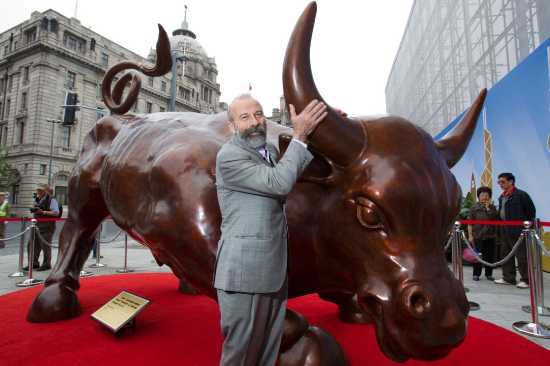 Arturo Di Modica junto a su escultura en Nueva York