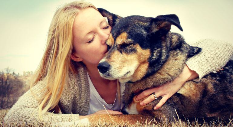 Una mujer abraza a su perro.