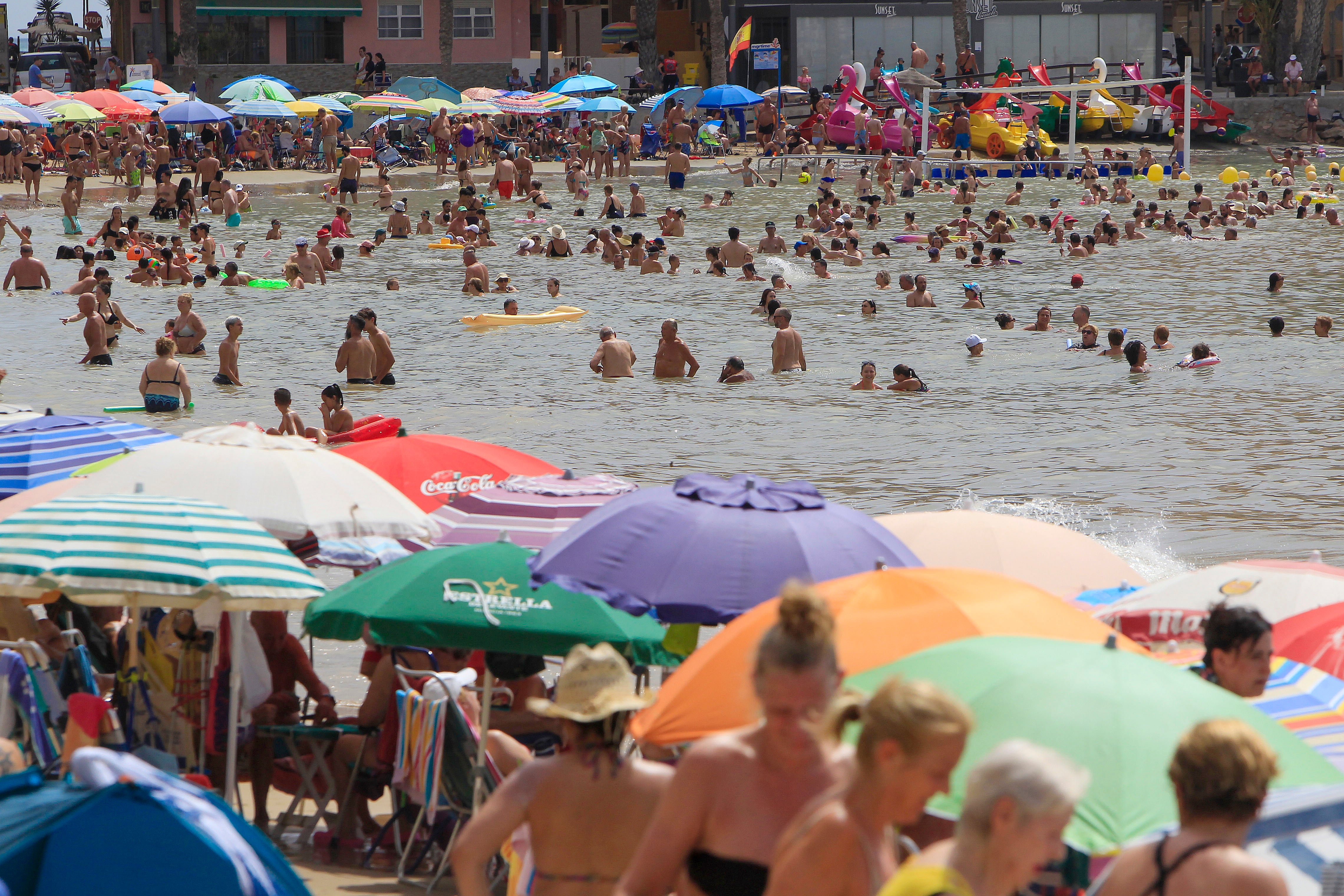 Un gran número de personas disfrutan del buen tiempo en la playa de El Cura de Torrevieja cuando la Agencia Estatal de Meteorología (Aemet) ha establecido para este miércoles, 31 de julio, el aviso naranja por temperaturas máximas de 42 grados en el interior sur de la provincia de Valencia. EFE/Kai Försterling