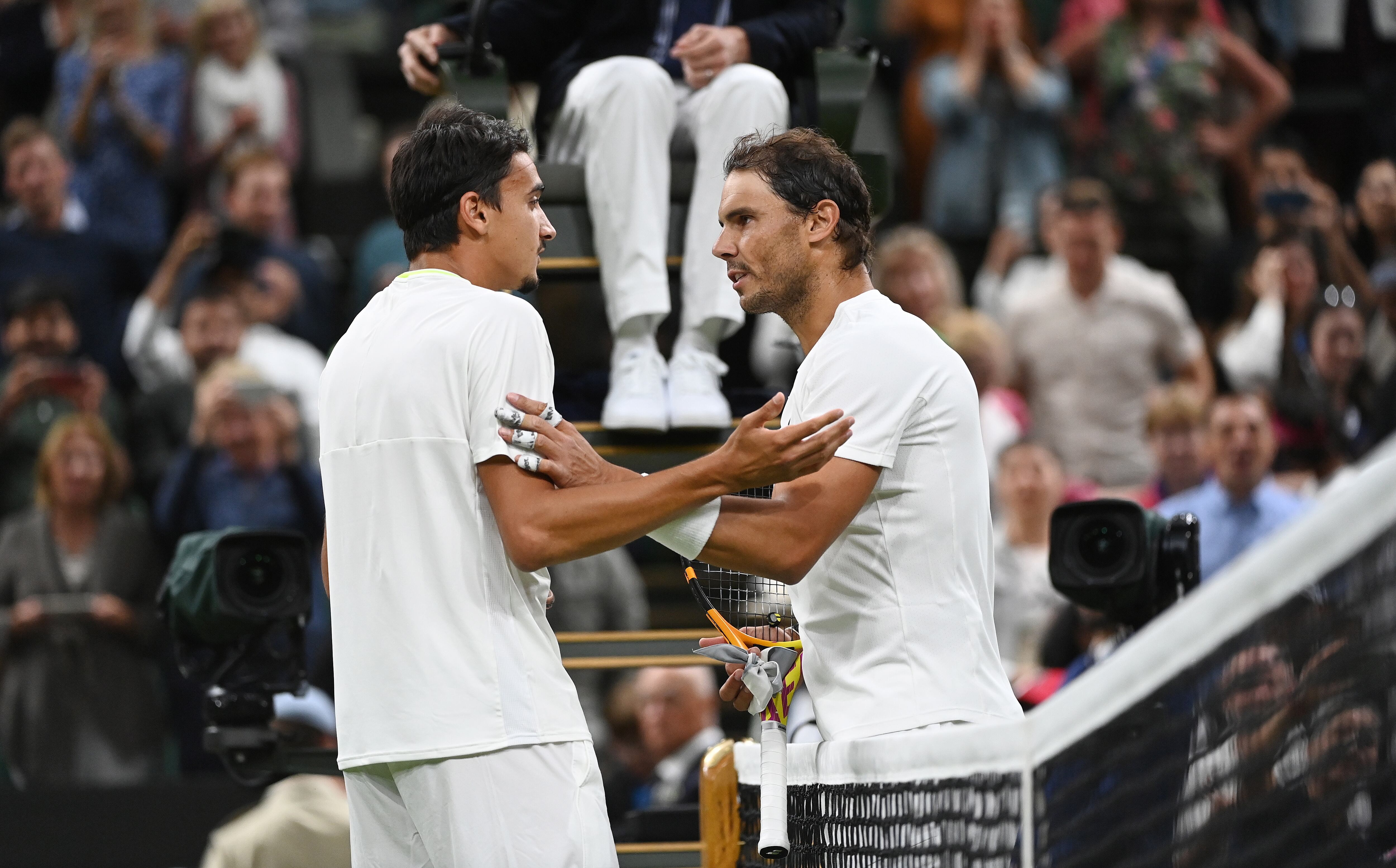 Rafa Nadal hablando con Sonego en la red