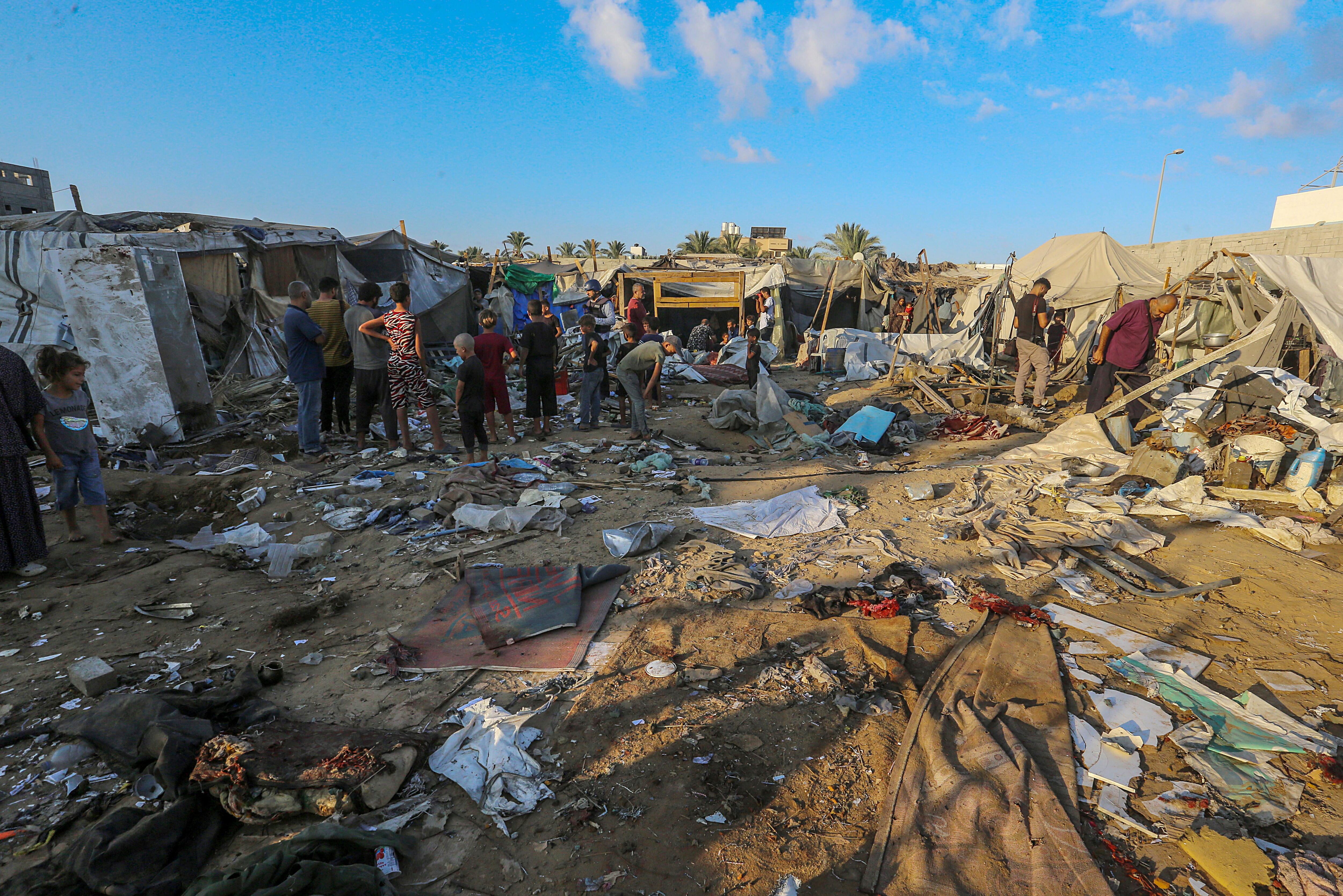 Palestinos desplazados internamente inspeccionan refugios destruidos tras un ataque militar israelí cerca del Hospital de los Mártires de Al-Aqsa en Deir Al Balah, en el centro de la Franja de Gaza