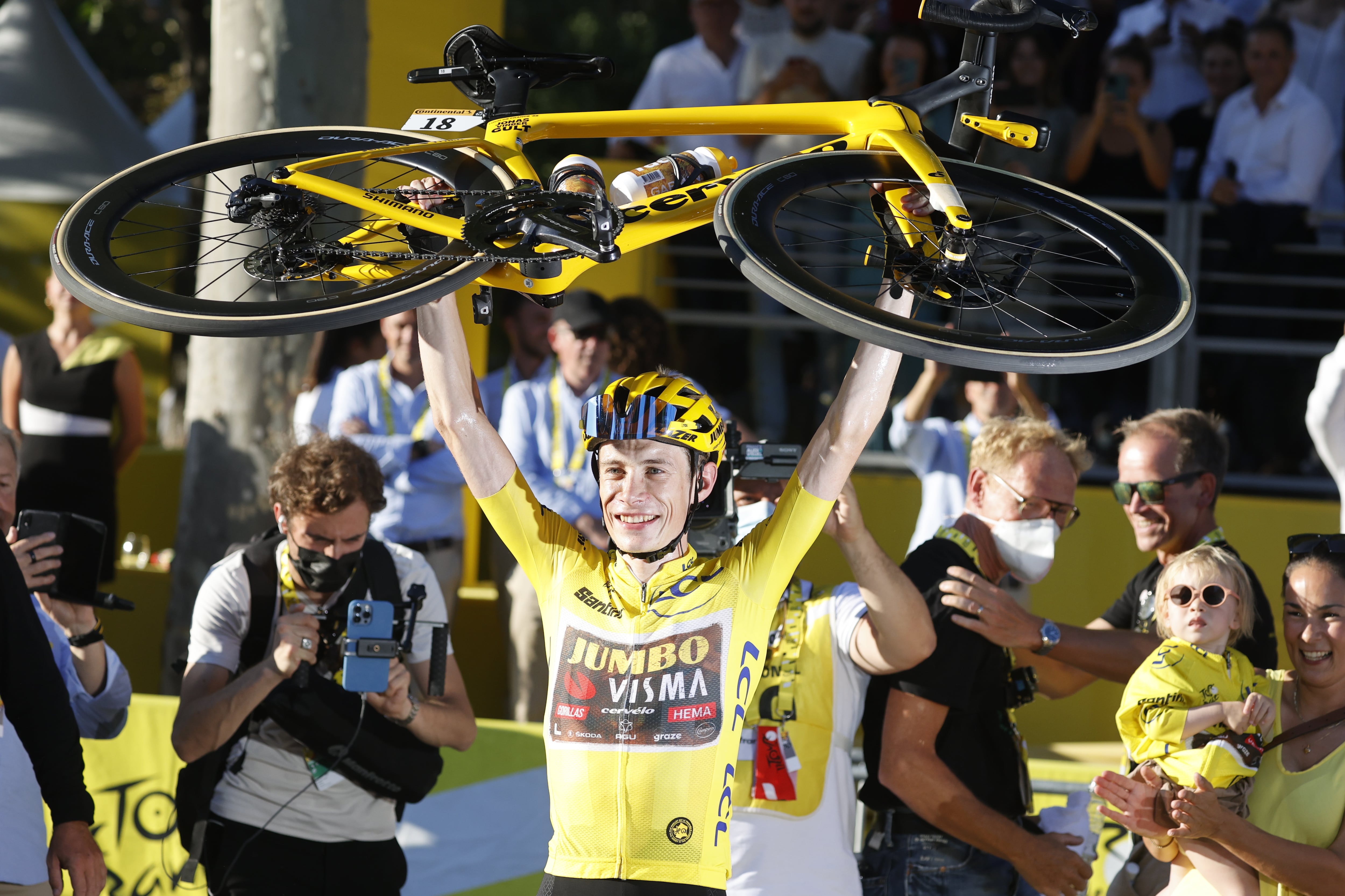 El ganador del Tour, Jonas Vingegaard, levanta su bicicleta en los Campos Elíseos.