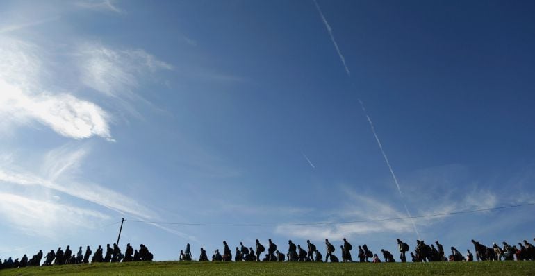 PASSAU, GERMANY - OCTOBER 28:  Arriving migrants walk across a field to a transport facility after been gathered by German police  at the border to Austria on October 28, 2015 near Wegscheid, Germany. Bavarian Governor Horst Seehofer has accused the Austr