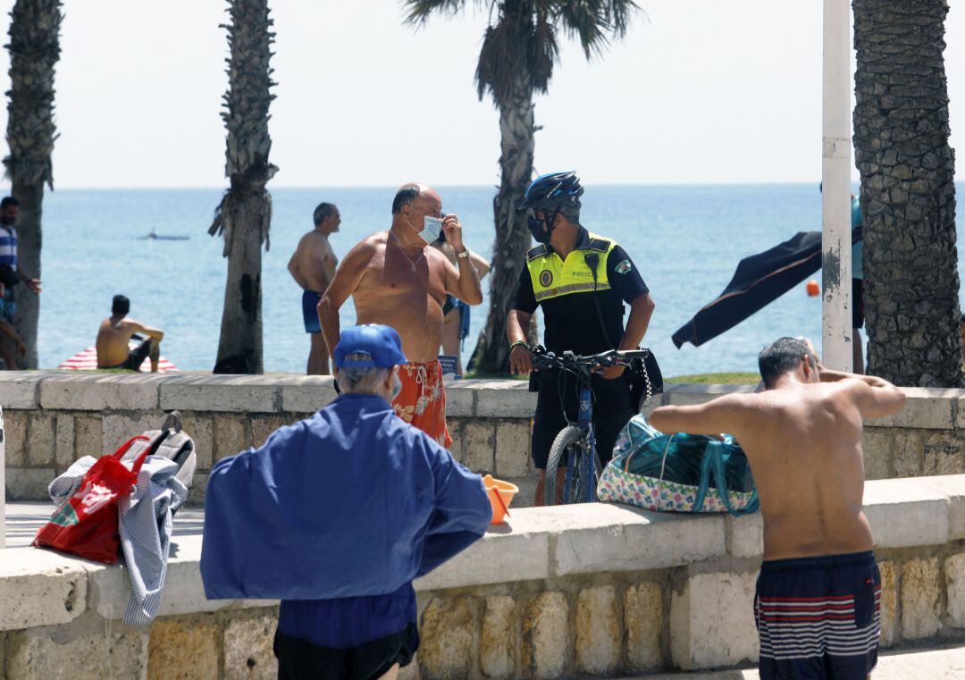 Policía Local informa a un bañista en la playa de La Malagueta