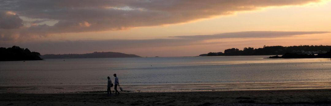 Una pareja disfruta del atardecer en la tarde del jueves en la localidad coruñesa de Cabanas.