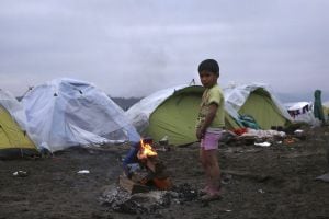 ID8 IDOMENI (GRECIA), 17/03/2016.- Un niño sirio se calienta junto a una hoguera en el campamento de acogida de Idomeni, Grecia, hoy, 17 de marzo de 2016. Los líderes comunitarios comenzarán hoy a buscar una vía legal para cerrar el acuerdo con Turquía so