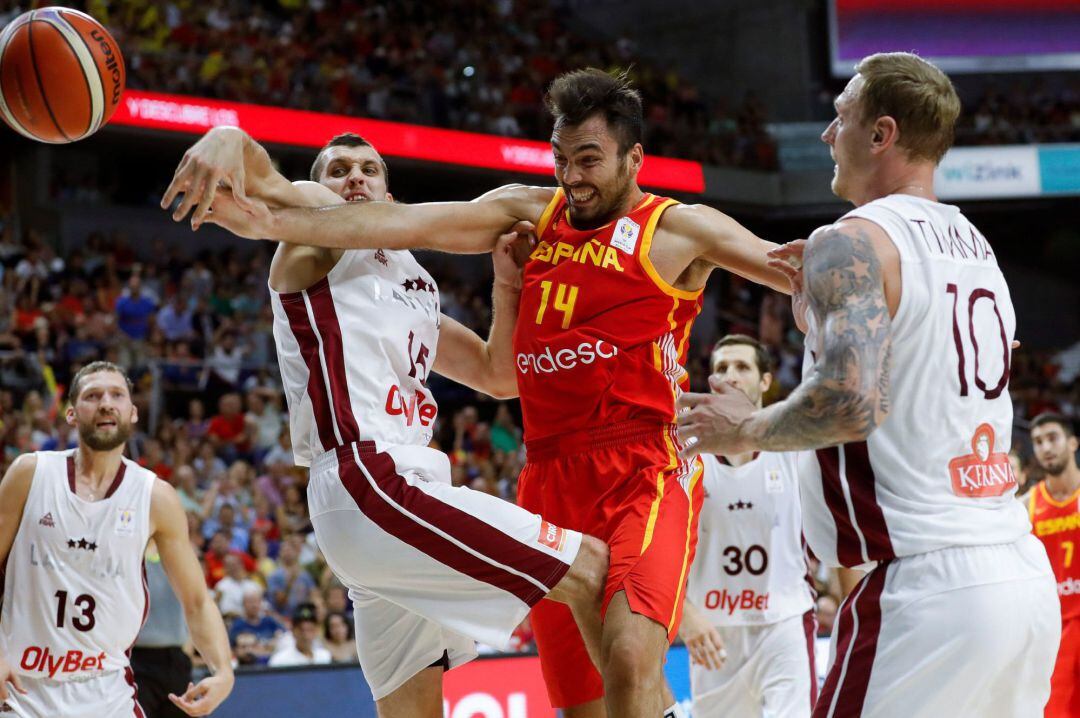 El ala-pívot de la selección de baloncesto de España, Pierre Oriola (c) y el base de Letonia, Janis Strelnieks, durante el partido clasificatorio para la Copa del Mundo FIBA entre España y Letonia, disputado hoy en el Wizink Center de Madrid.