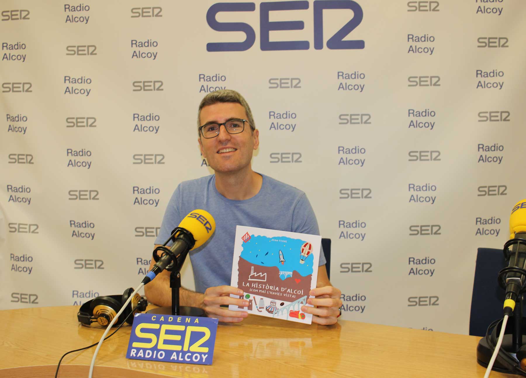 Joan Ferre, amb una exemplar de la publicació, en l'estudi central de Radio Alcoy