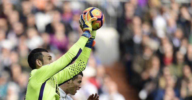 Diego López atrapa un balón ante Cristiano Ronaldo