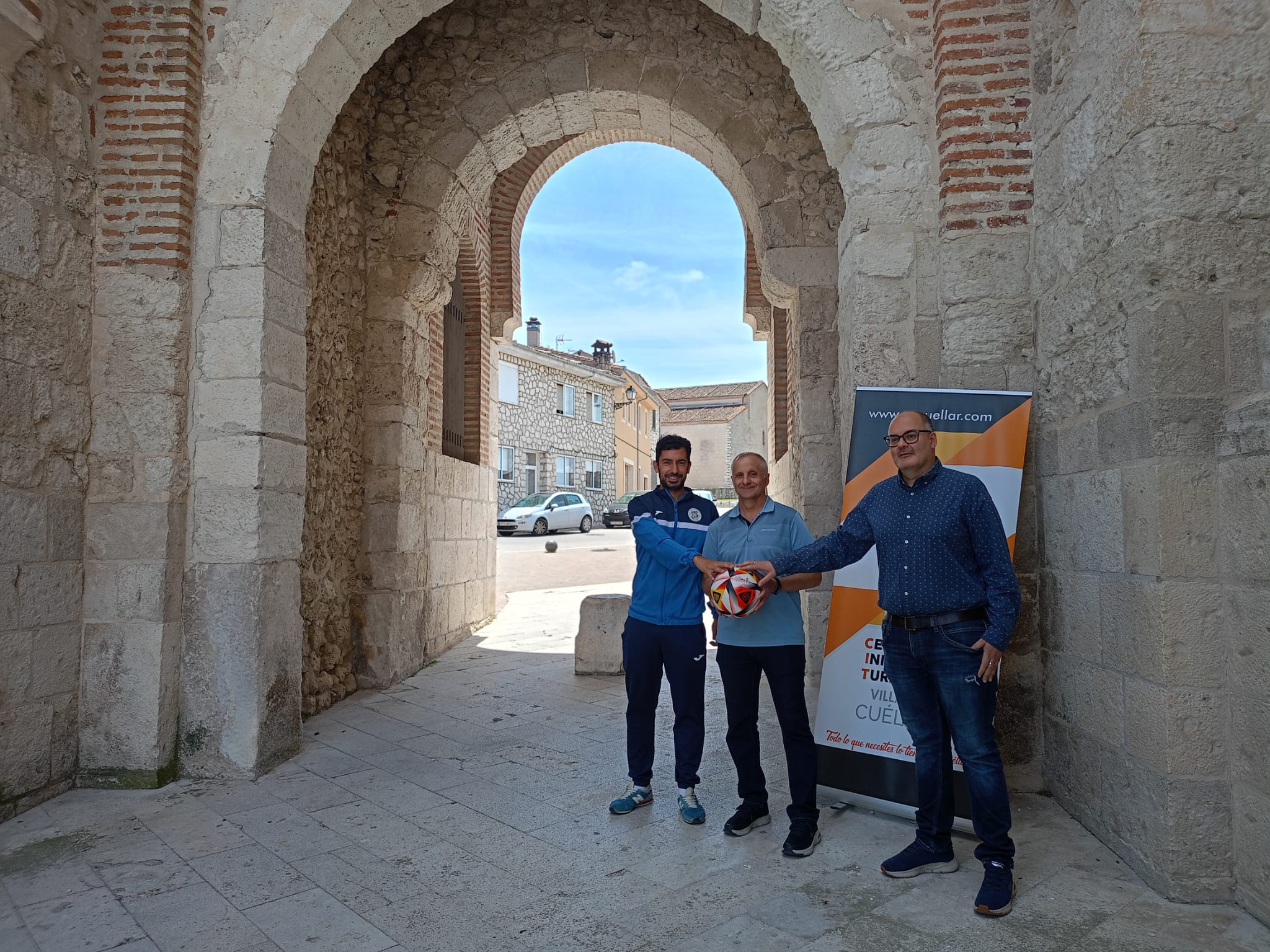 Daniel Martin y José Luis Fraile del CD Cuéllar junto a Ángel Carlos Hernando presidente del CIT Villa de Cuéllar junto al arco de San Basilio emblema turístico de Cuéllar