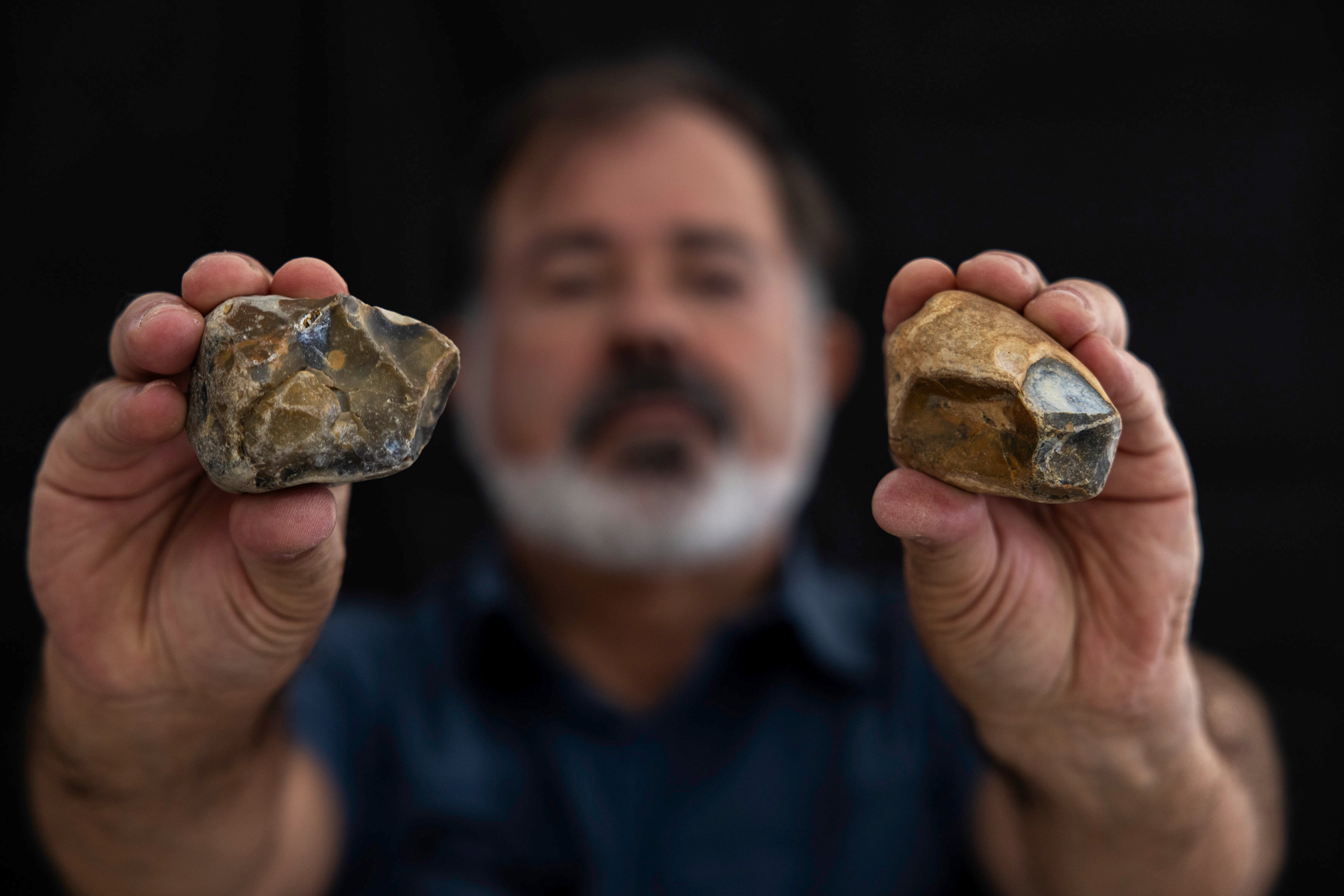 MÁLAGA, 01/09/2024.- El fotógrafo Juan María Álvarez muestra unos núcleos tallados del Paleolítico. Piedras talladas del Paleolítico, como puntas musterienses, raederas o denticulados, además de moluscos y restos óseos de animales del período Holoceno, son algunos de los cientos de vestigios prehistóricos que un vecino de Málaga ha hallado casualmente en unos montículos de arena depositada en la playa Sacaba. EFE/Jorge Zapata.
