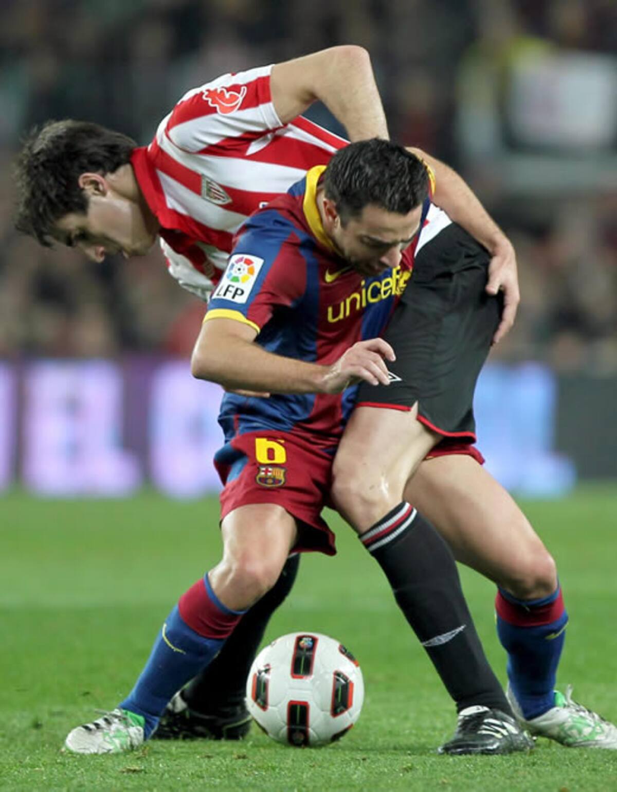 El centrocampista del FC Barcelona Xavi Hernández lucha un balón con el mediocentro del Athletic Club Javi Martínez (i) durante el partido correspondiente a la vigésimo cuarta jornada de Liga de Primera División que ambos equipos disputan esta noche en el