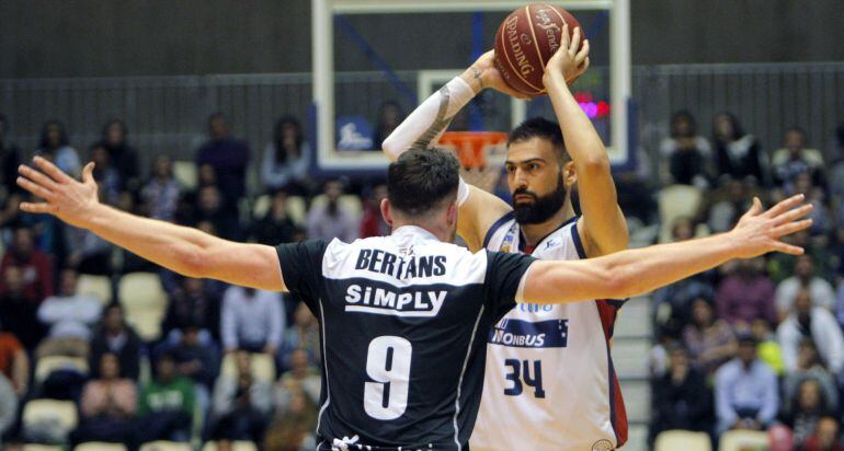 El jugador del Bilbao Basket, Dairis Bertans (de espaldas), defiende el ataque del nuevo jugador del Obradoiro el alero Kostas Vasileiadis, durante el encuentro de la jornada 31 de la Liga ACB que se está celebrando esta tarde en el Multiusos de Sar de Sa