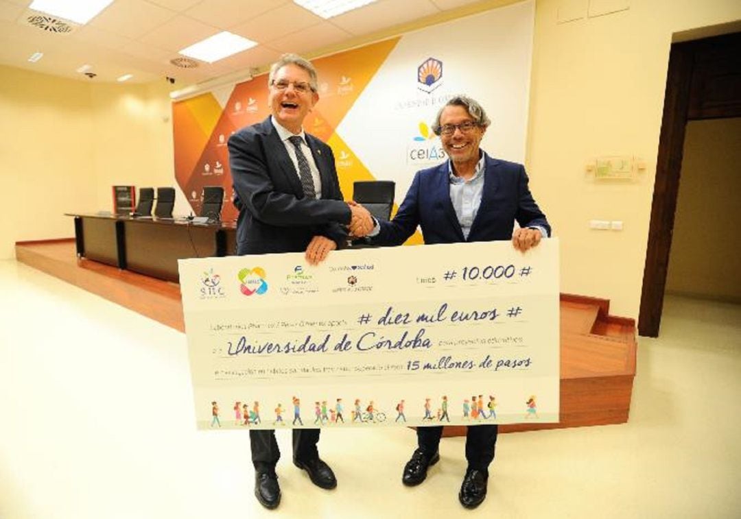 El vicerrector, Lorenzo Salas, y el CEO de Pharmex, Carlos Santé, muestran el cheque donado para becas educativas.