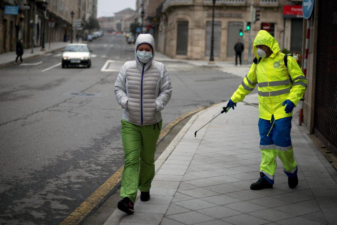 Un trabajador del servicio municipal de limpieza desinfecta una calle de Ourense