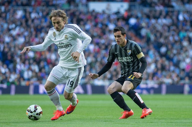 Luka Modric se lleva el balón ante Juanmi, el delantero del Málaga