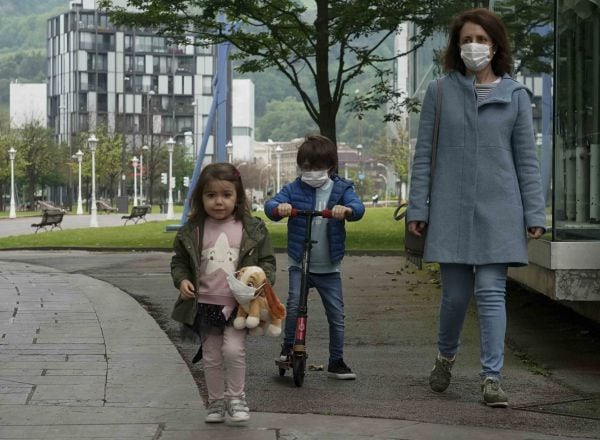 Una mujer pasea junto a una niña y un niño en patinete en el primer día en el que los menores de 14 años pueden salir a la calle, en Bilbao (País Vasco/España) a 26 de abril de 2020.  26 ABRIL 2020;BILBAO;PAÍS VASCO;MENORES;NIÑOS;CORONAVIRUS;COVID-19;  H.Bilbao / Europa Press  26/04/2020