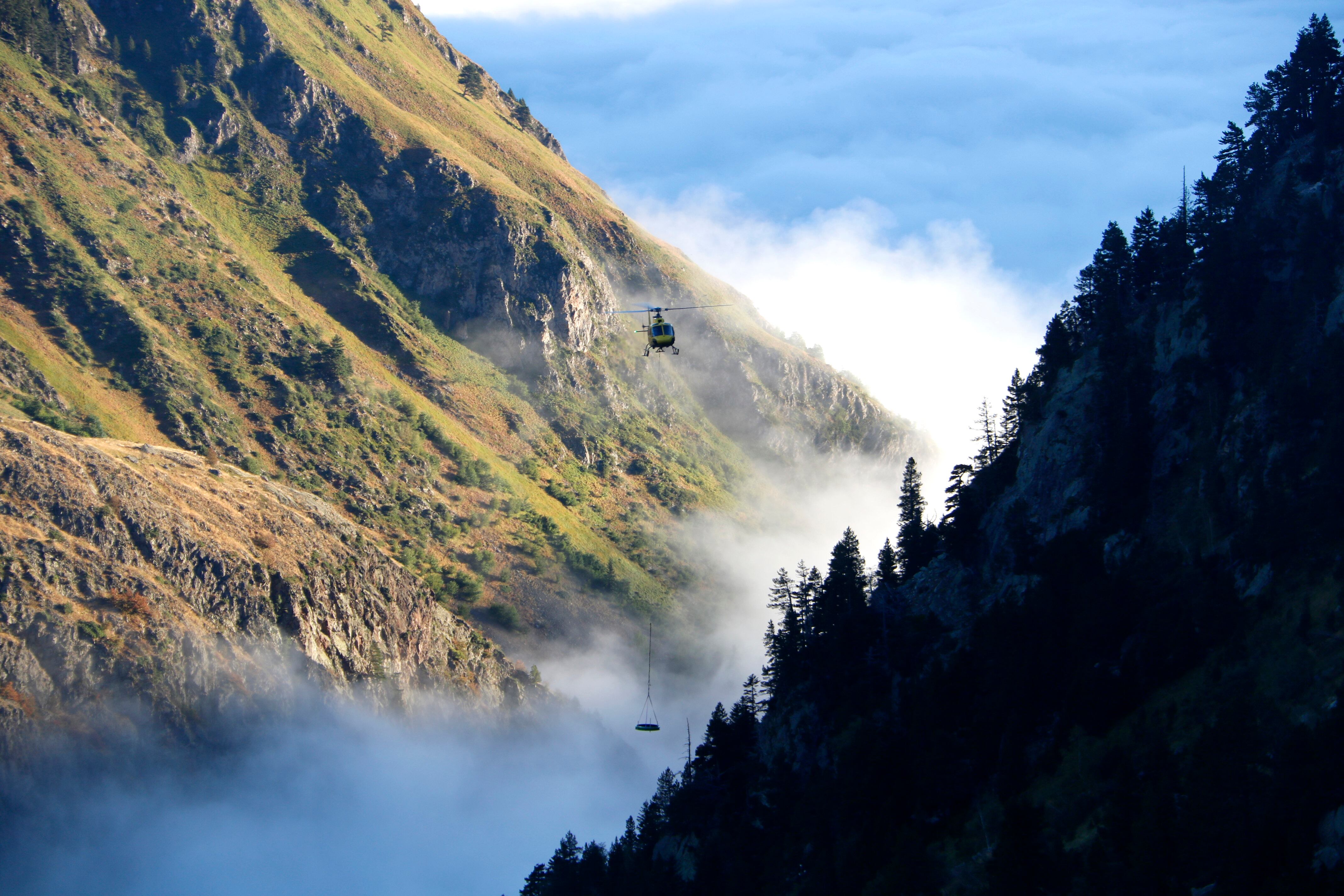 Helicòpter sobrevolant la vall d'Arties amb material pesat per canviar les vàlvules de la presa de la Restanca