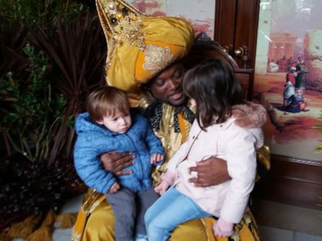 Dos niños hablan con el Rey Mago Baltasar.