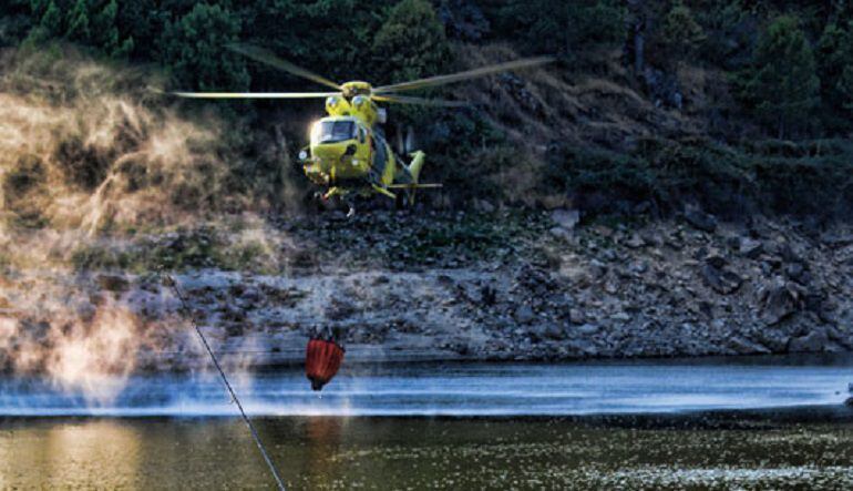 El helicóptero de la base del Puerto del Pico cargando agua, durante las labores de extinción de un incendio