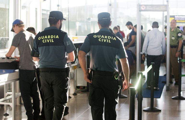 Agentes de la Guardia Civil custodian los accesos a las puertas de embarque en un aeropuerto.