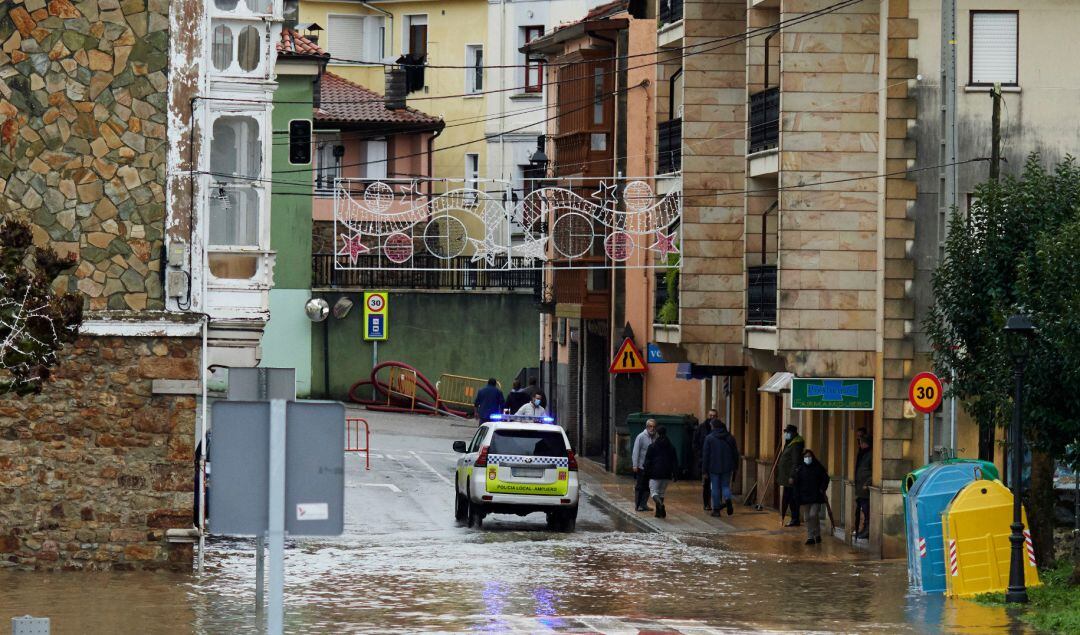 Un vehículo de policía circula por una vía inundada en Ampuero, Cantabria, (España). 