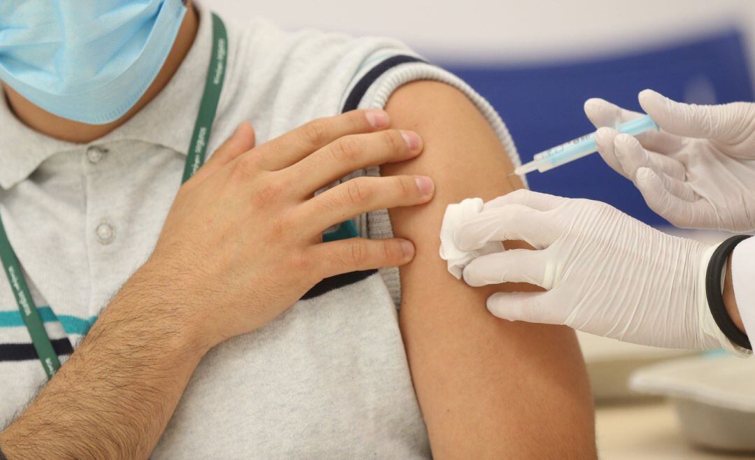 Una persona se vacuna en un punto de vacunación.