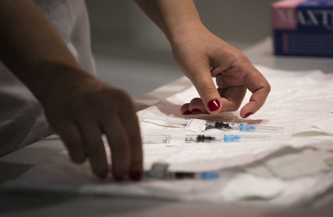 Una sanitaria con varias dosis de la vacuna de Pfizer