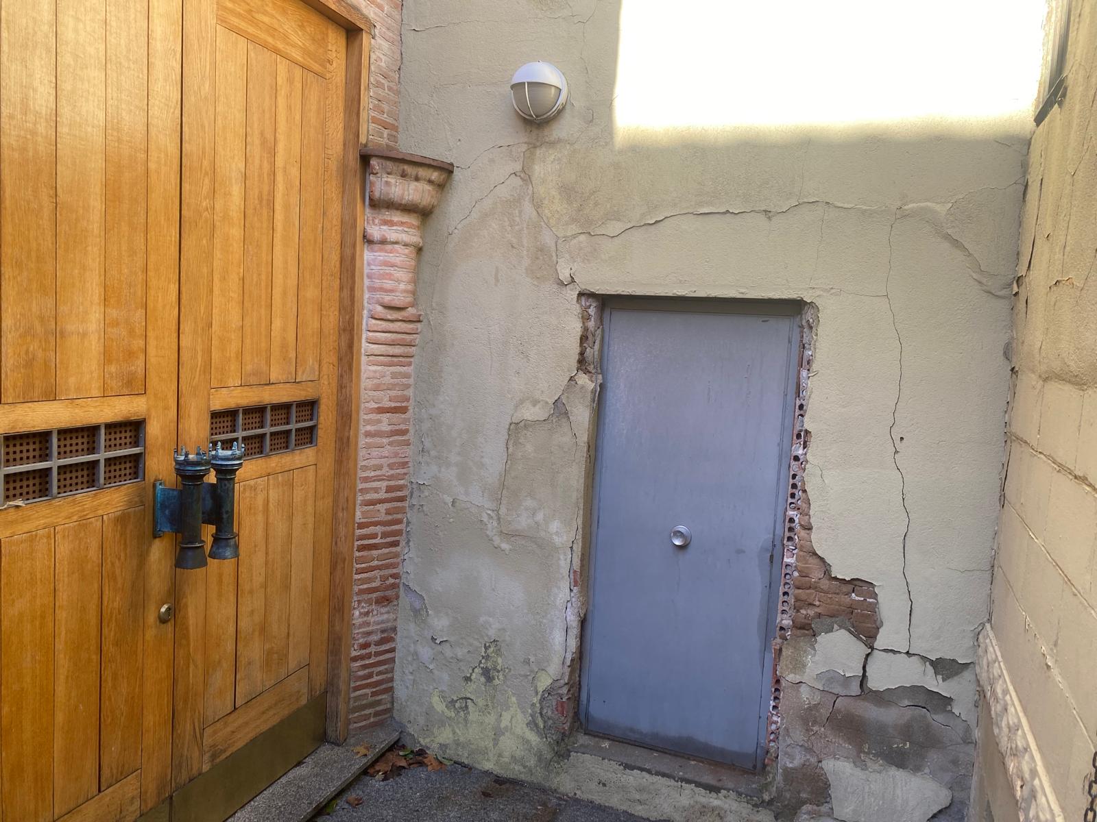 Muro en mal estado junto a la puerta de la capilla Luis de Lucena