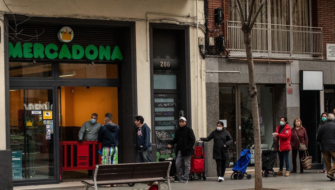 Varias personas hacen cola frente a un Mercadona de Barcelona.