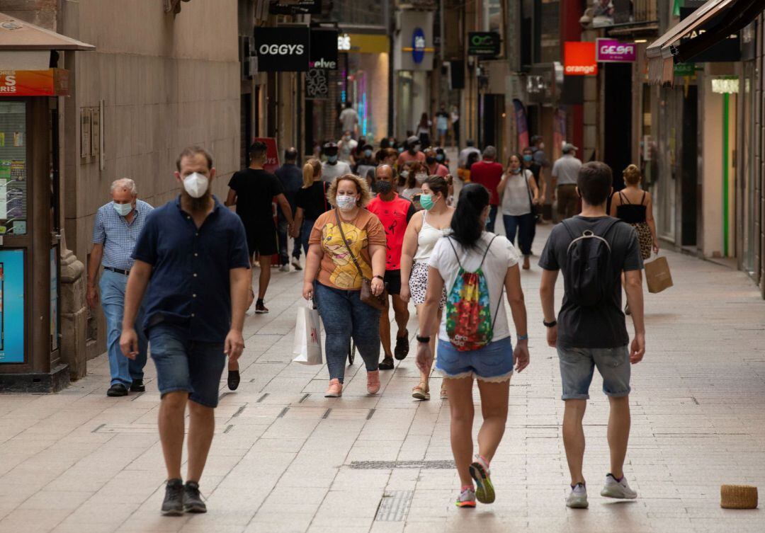 Varias personas caminan por el centro comercial e histórico de Lleida este lunes, cuando la Generalitat estudia qué medidas adoptar en Lleida después de que una juez haya impedido el endurecimiento del confinamiento en la comarca del Segrià. 