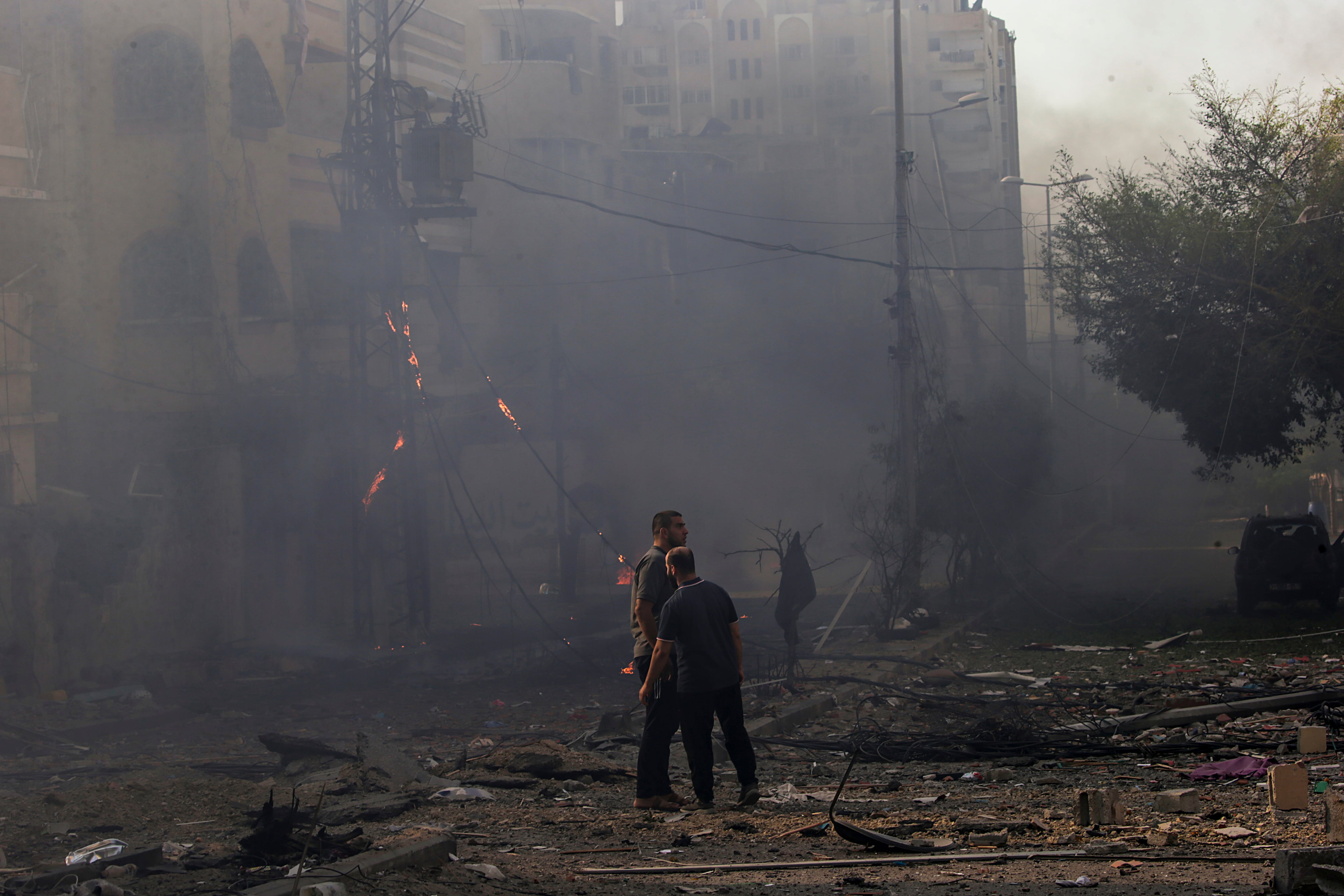 Palestinos en una zona bombardeada por Israel